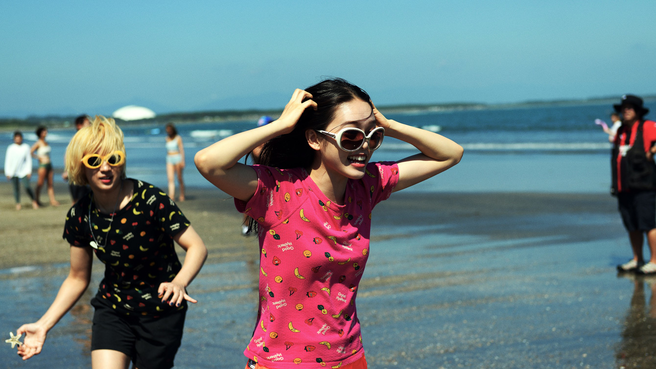 Chisato looks relaxed and happy on the beach, while Mahiro approaches holding a starfish